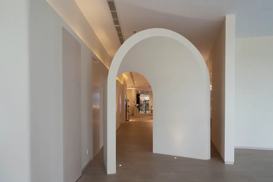 A curved plaster archway in a white hallway