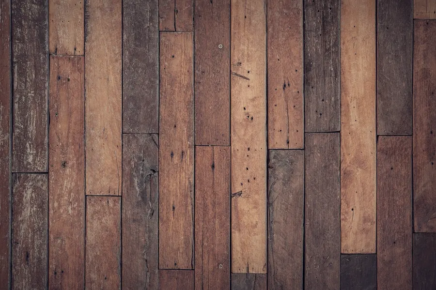 Aged parquet floorboards in a herringbone rhythm
